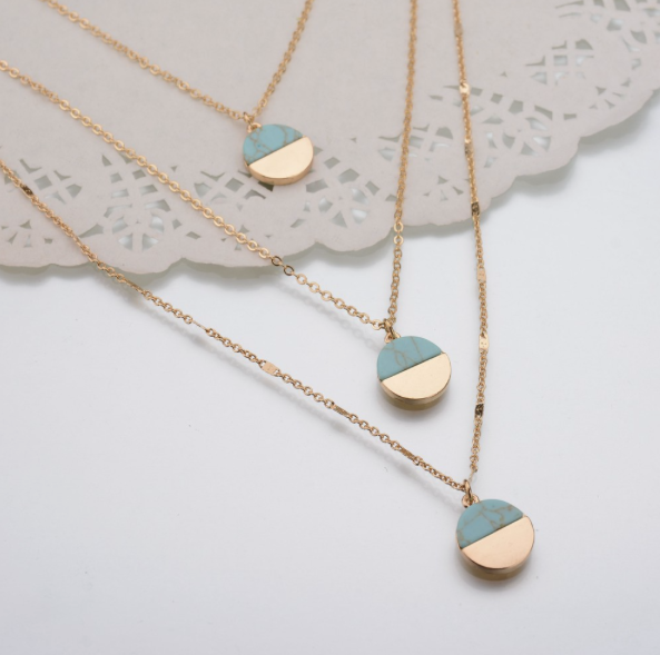 Ce collier se compose de trois chaînes dorées et de trois pendentifs turquoise imitation marbre. Pour un look très chic.